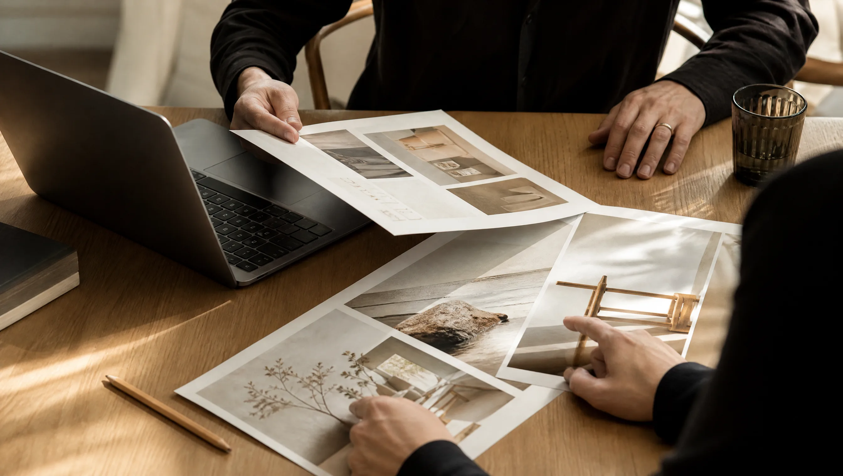 Manos revisando tableros creativos sobre escritorio de roble